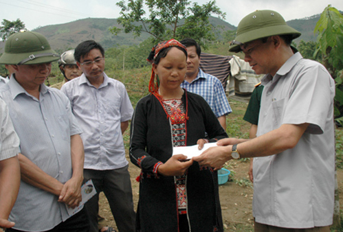 Phó chủ tịch Thường trực UBND tỉnhTạ Văn Long trao tiền hỗ trợ của tỉnh cho hộ gia đình anh Nguyễn Văn Sang ở bản Sâng 1, xã Tân Lập