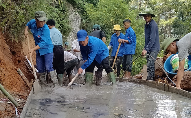 Đoàn viên thanh niên xã Xà Hồ cùng bà con nhân dân thôn Háng Xê tham gia bê tông hóa đường giao thông nông thôn.