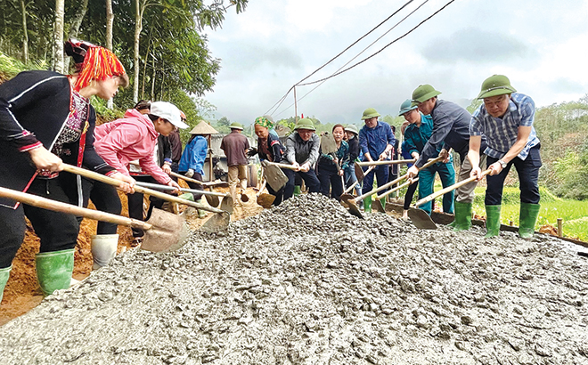 Lãnh đạo, cán bộ huyện Yên Bình và nhân dân xã Tân Nguyên tham gia bê tông hóa đường giao thông nông thôn tại thôn Đèo Thao (ảnh tư liệu).